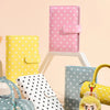 A collection of colorful storage books and binders in various colors like pink, yellow, blue, and white, displayed on a light