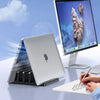 A silver laptop is placed in a black stand next to a monitor, demonstrating better airflow.