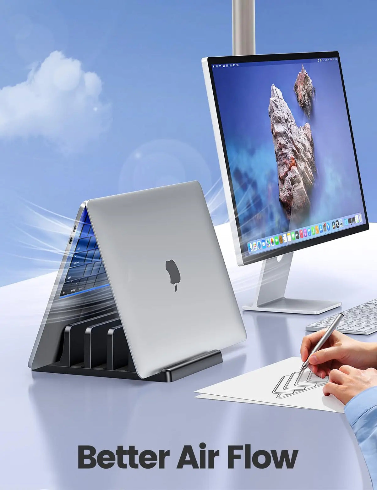 A silver laptop is placed in a black stand next to a monitor, demonstrating better airflow.