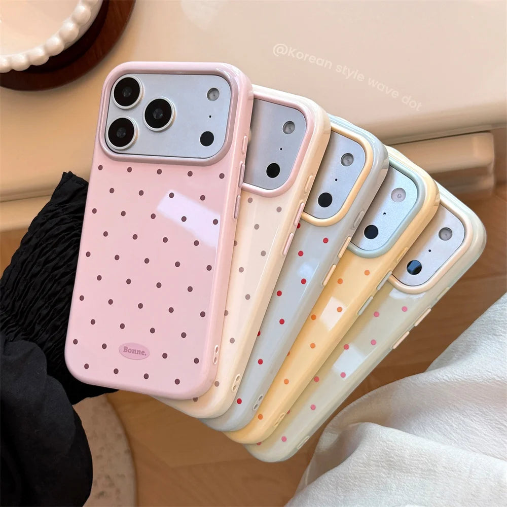A pink and cream candy polka dot shockproof phone case for an iPhone shown in a close-up angle.