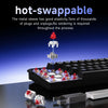A close-up view of a mechanical keyboard with hot-swappable switches and plugs being inserted or removed.