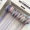 A stack of purple and pink washi tape rolls is displayed next to its packaging.