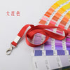 Porta credencial resistente rojo con cordón y muestras de colores Pantone en fondo blanco.