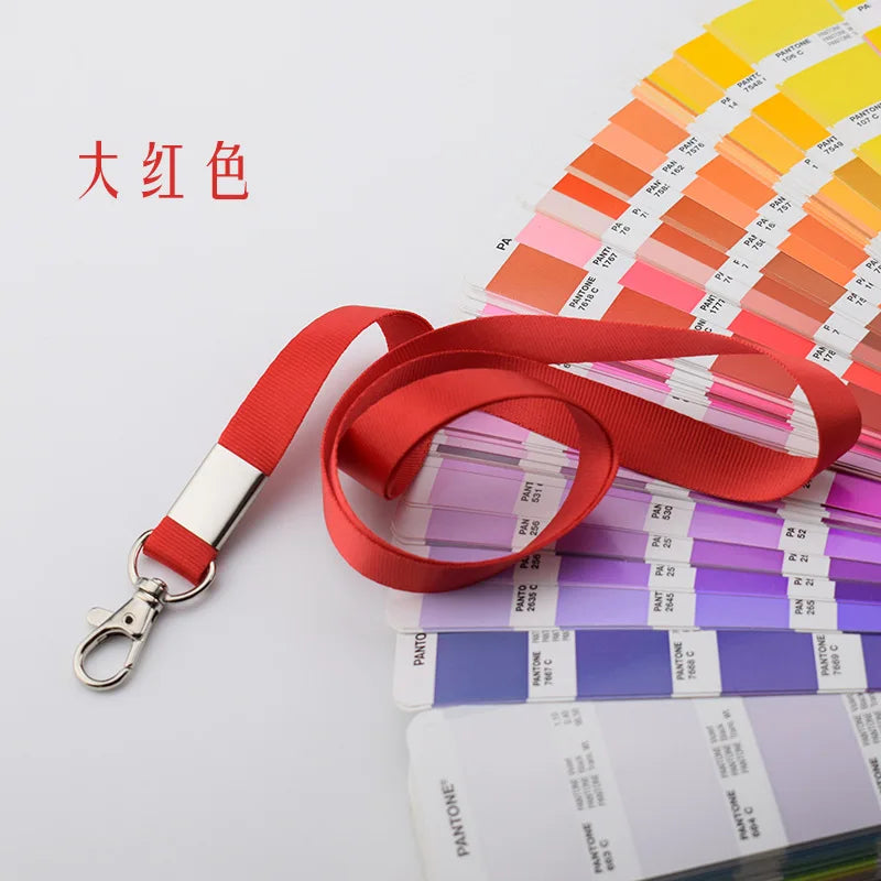 Porta credencial resistente rojo con cordón y muestras de colores Pantone en fondo blanco.