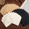 Paquete de invitaciones y tarjetas para boda en sobres de cartón kraft, dispuestos sobre una superficie de madera oscura.