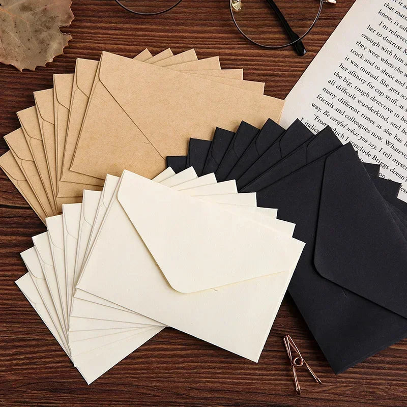 Paquete de invitaciones y tarjetas para boda en sobres de cartón kraft, dispuestos sobre una superficie de madera oscura.