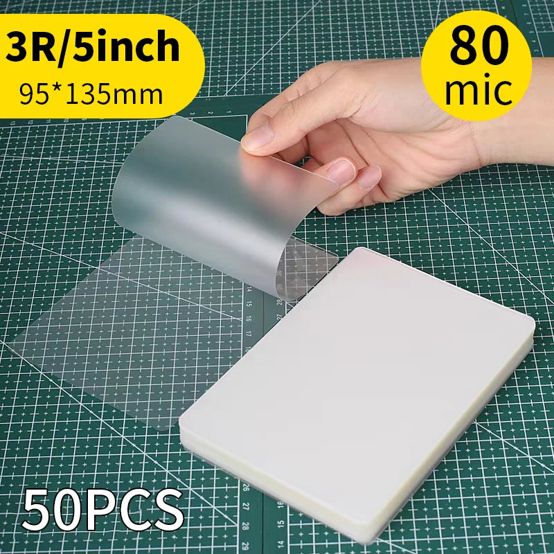 A hand holds a 3R/5inch thermal laminating pouch, measuring 95x135mm, next to a white pouch and a ruler.
