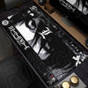 A black mouse pad featuring a stylized Death Note design with white and gray graphics, placed on a wooden desk surface.