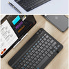 A black portable Bluetooth keyboard is shown in various contexts, including next to an iPad and a smartphone, and being used 