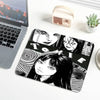 A black and white illustration of Tomie from Junji Ito is printed on a mouse pad with stitched edges.