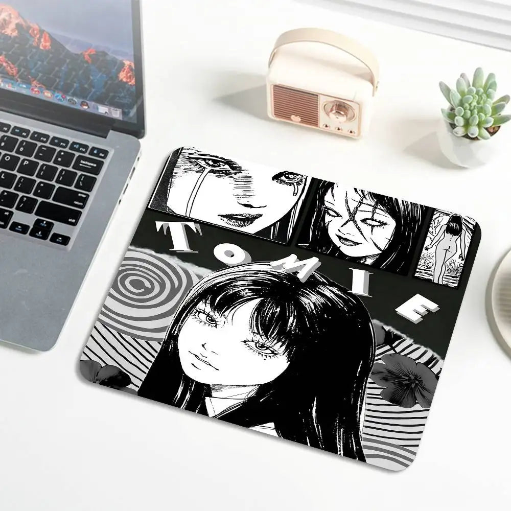 A black and white illustration of Tomie from Junji Ito is printed on a mouse pad with stitched edges.