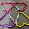 A collection of five colorful heart-shaped spring clasps and carabiner keychains in pink, red, purple, and yellow.