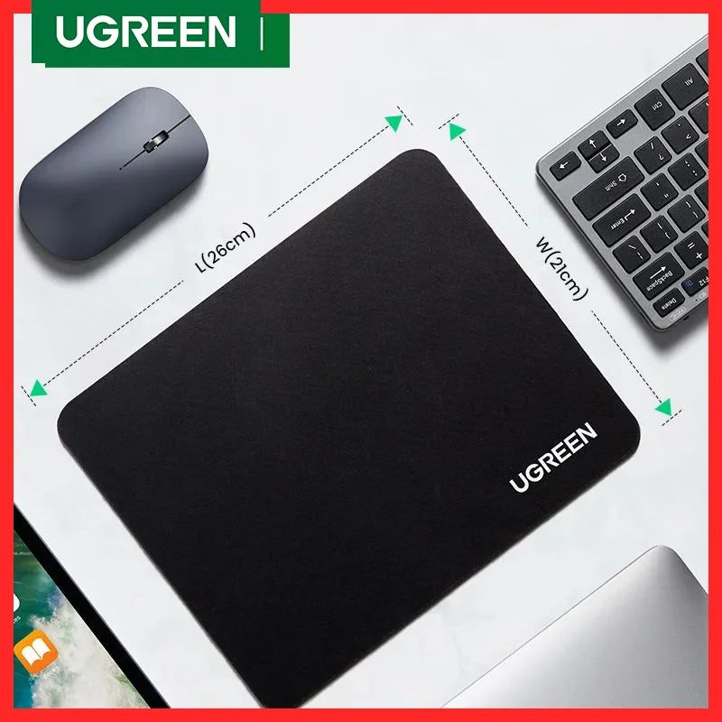 A black non-slip rubber mouse pad and a wireless mouse are shown on a white desk surface.