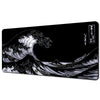A black and white illustration of a large ocean wave on a desk mat.