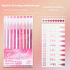 A set of nine pink watercolor gel pens packaged in a box with a grid notebook and color chart.