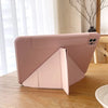 A pink magnetic protective case for an iPad, shown on a wooden surface.