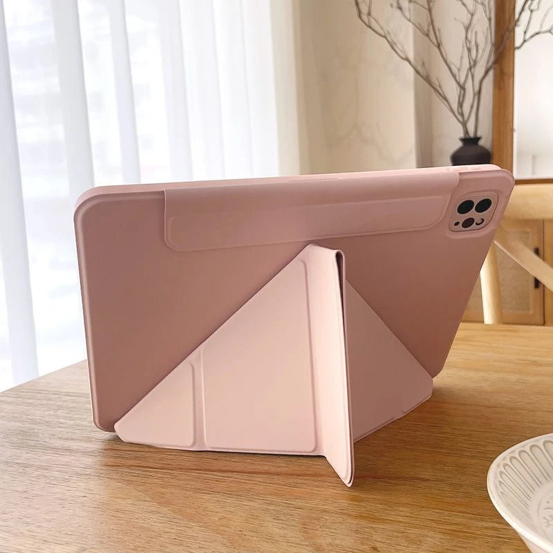 A pink magnetic protective case for an iPad, shown on a wooden surface.