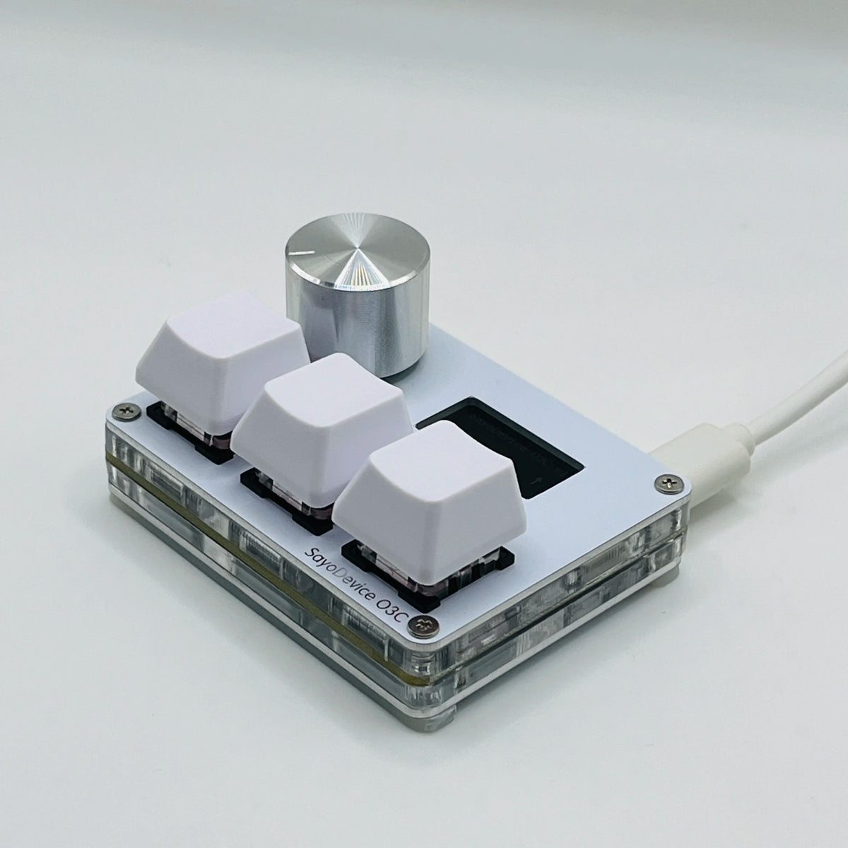 A close-up view of a white magnetic rapid trigger keyboard switch with a silver top piece and a white cable.