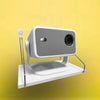 A white wall-mounted projector stand with a housing and lens is displayed against a yellow background.