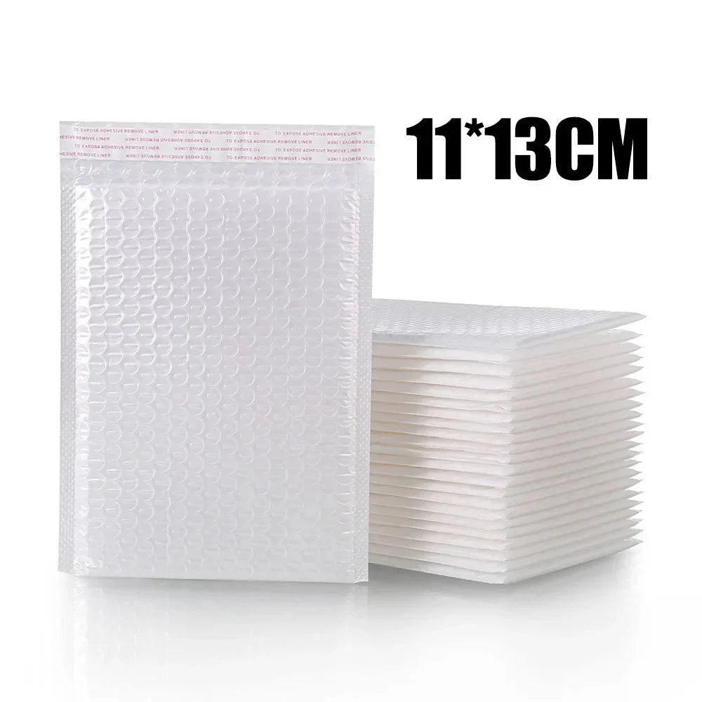 Une pile d'enveloppes blanches rembourrées, mesurant 11x13cm, pour l'expédition et les cadeaux.