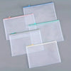 A set of clear mesh zipper bags in white and pink are displayed on a gray surface for classroom or organization use.