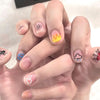 Une main présentant divers designs de nail art colorés en 3D sur les ongles.