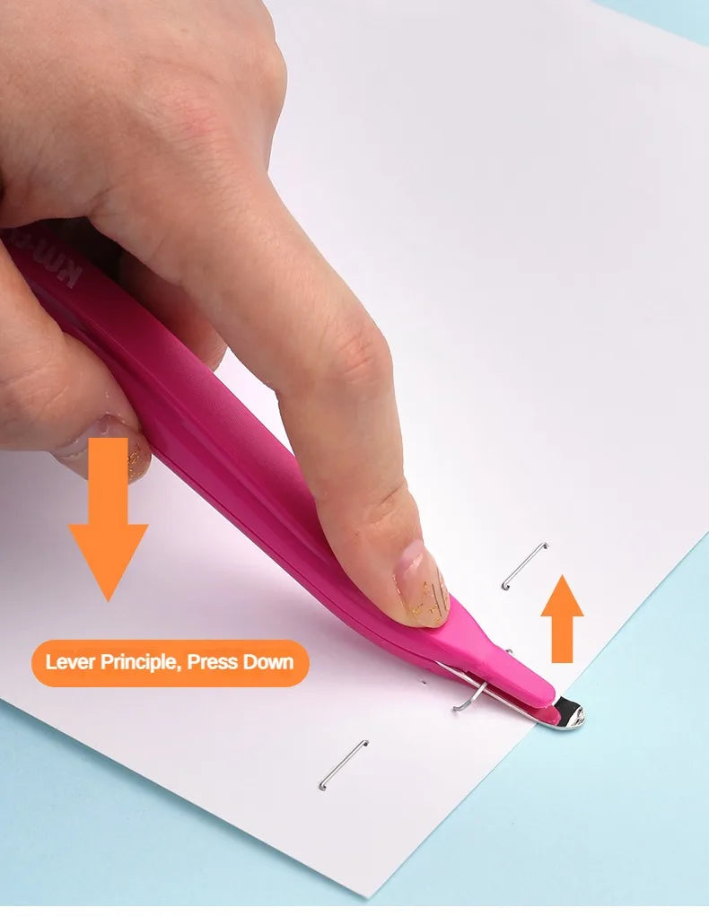 A hand is pressing down on a pink portable magnetic staple remover tool to remove staples from paper.