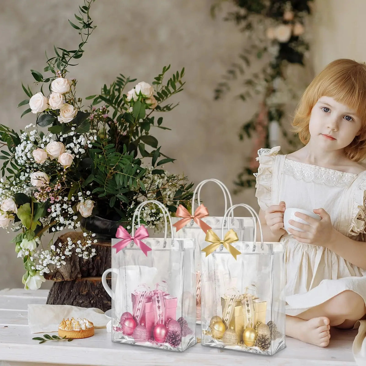 Una niña sostiene una bolsa de mano transparente de PVC llena de artículos decorativos rosa y dorado.