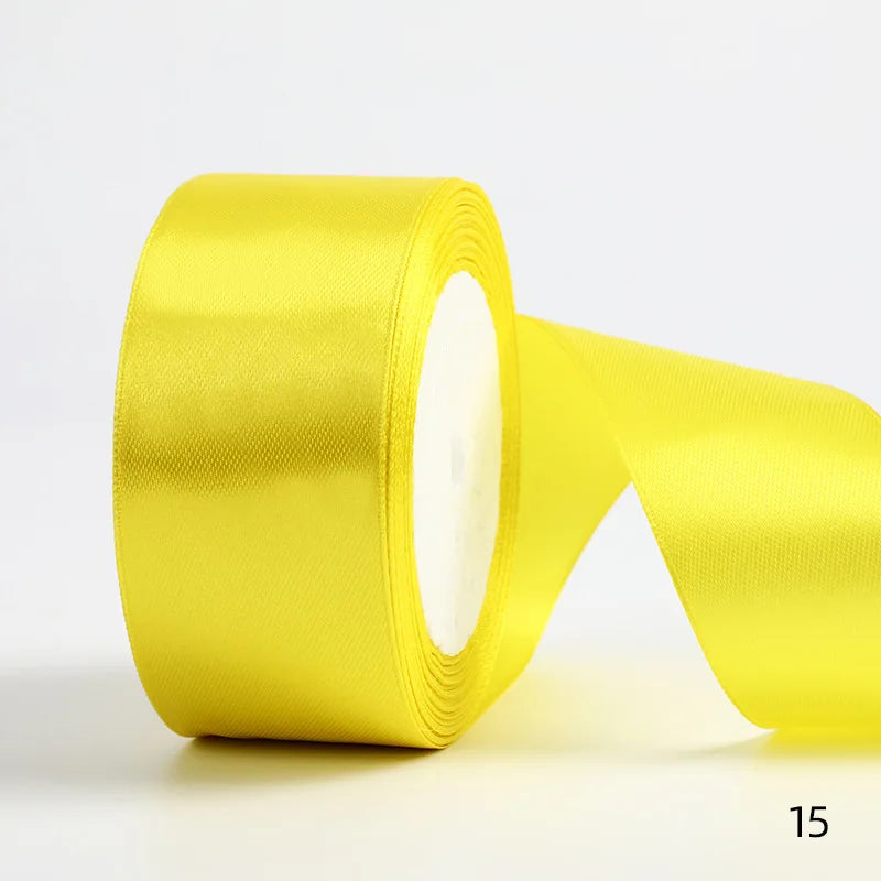 A roll of bright yellow satin ribbon used for gift wrapping or DIY crafts.