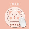 A round, light pink mouse pad featuring a cute cat face design.