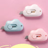 Two portable utility knives in white and light blue plastic are shown against a pink background.