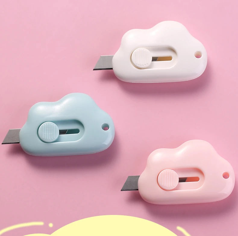 Two portable utility knives in white and light blue plastic are shown against a pink background.