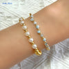 Gold-plated shell pearl beaded bracelet worn on a wrist.