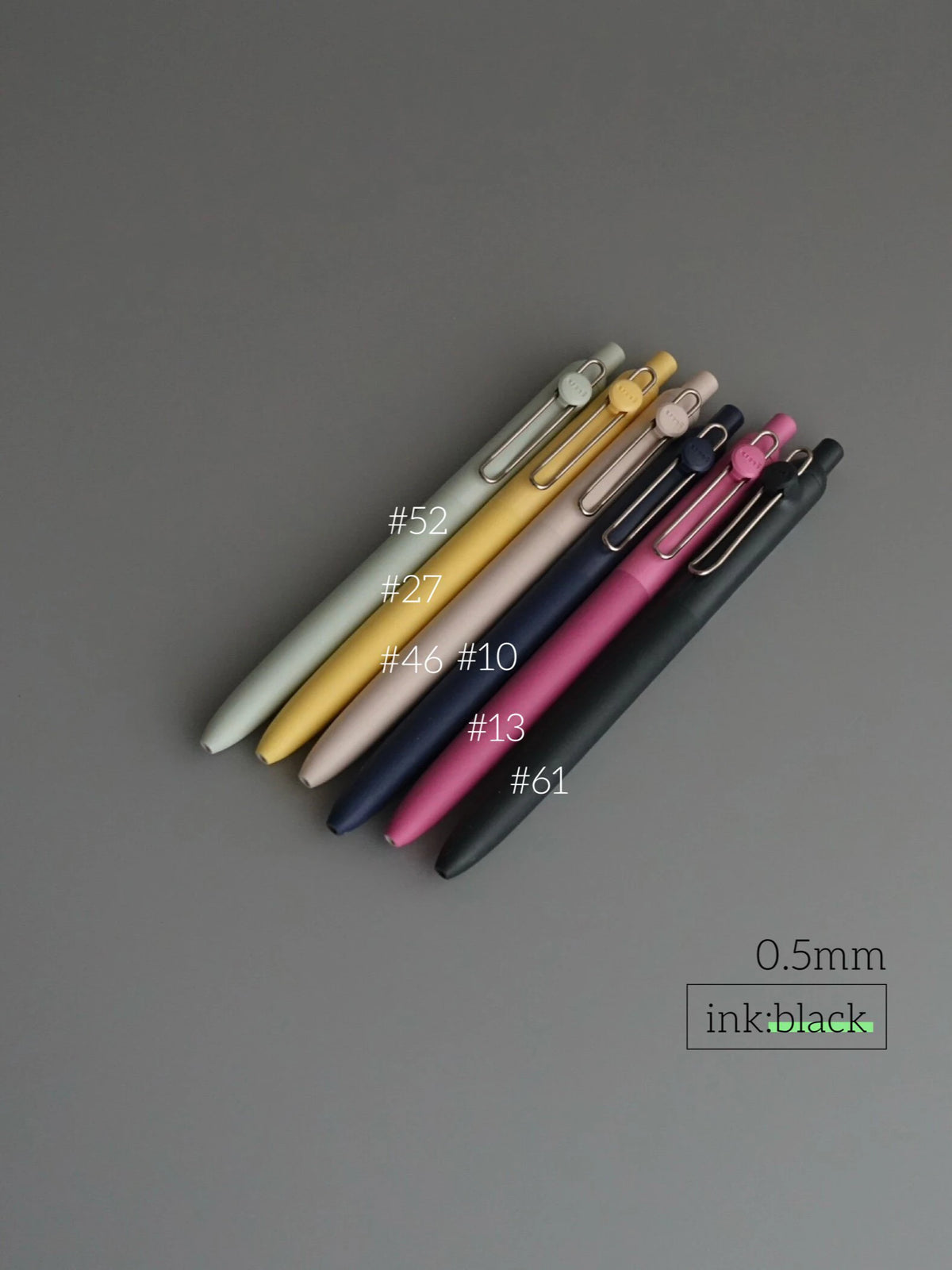 A collection of precision gel pens in various colors and finishes, including gold, silver, pink, purple, and black.