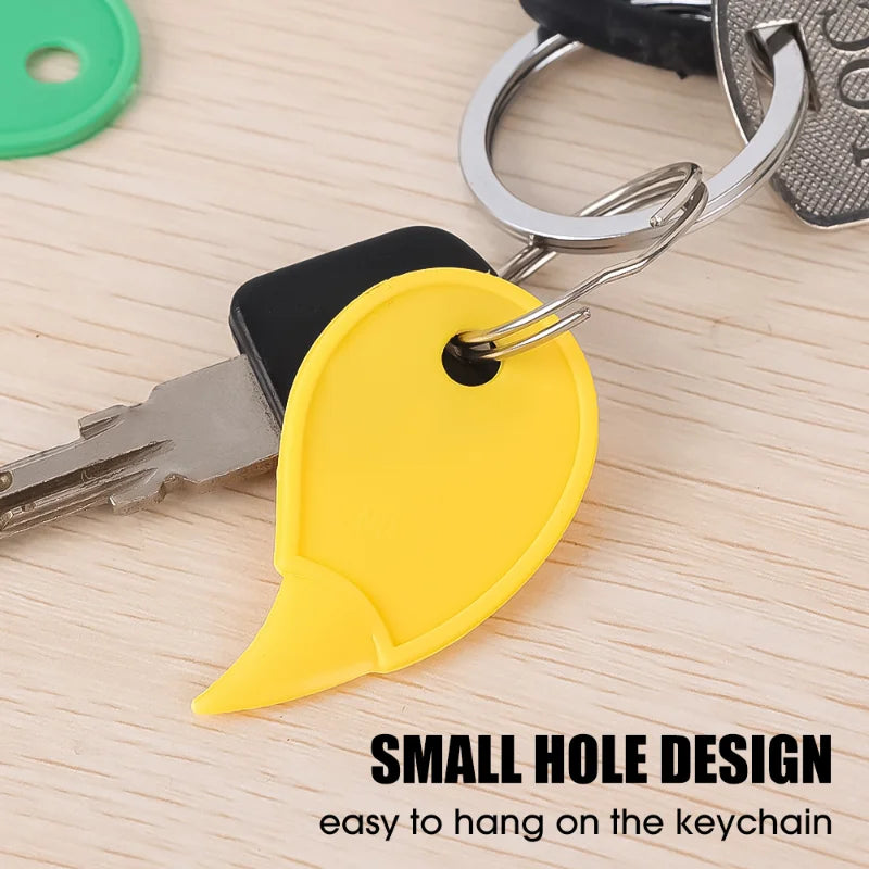 A yellow plastic tag with a small hole design attached to a keychain and a key.