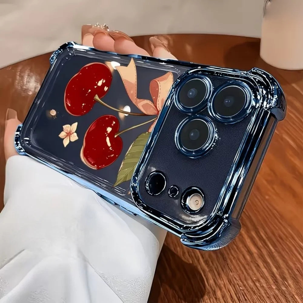 A dark blue iPhone case with a cherry bow pattern and electroplated finish is held in a person's hand.