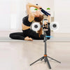 A person is using a 360° rotatable selfie stick tripod with face tracking and dual light to take a photo.