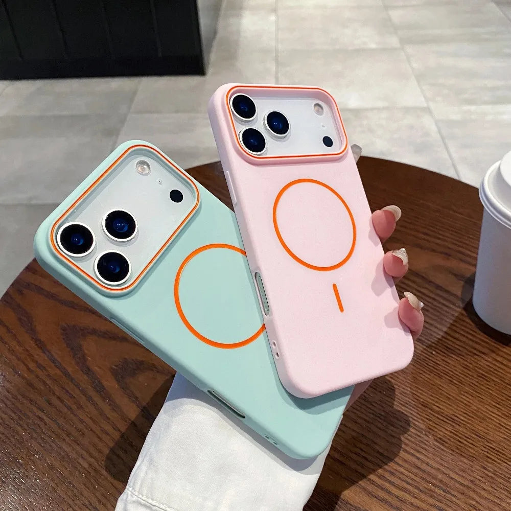 A pink phone case with an orange circular design is displayed on a wooden table.