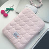 Pink quilted laptop sleeve with a matching pink beaded bracelet and green charm