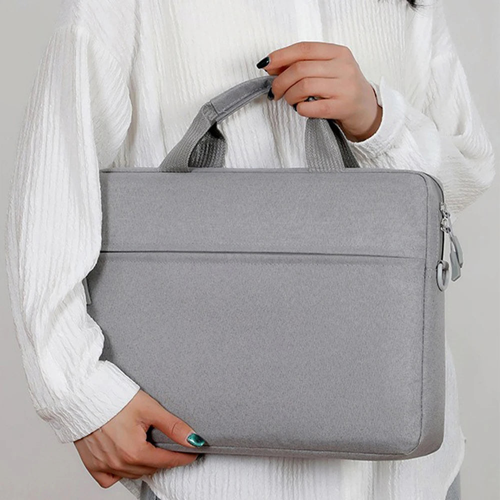 A person is holding a gray premium laptop sleeve for notebooks.