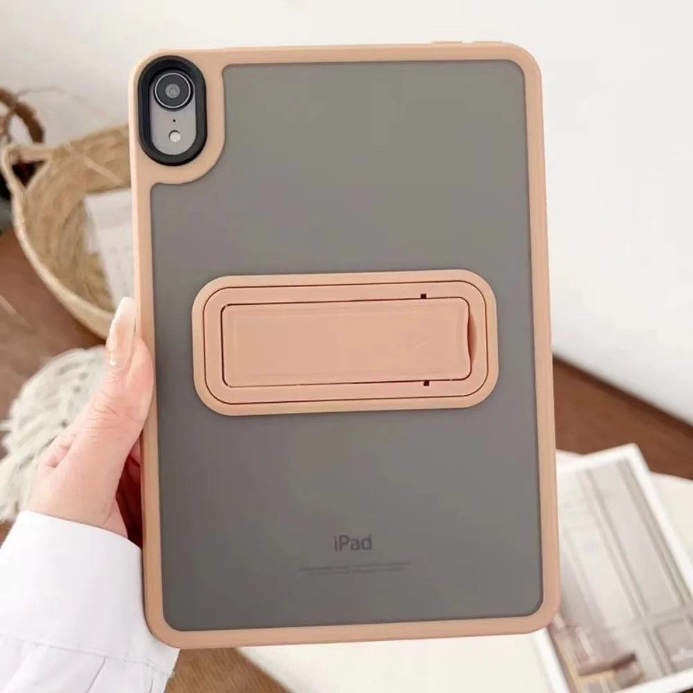 A hand holds a beige matte protective case for an iPad, showing the device's back and camera module.