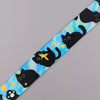 A colorful lanyard featuring repeating black cartoon cats against a blue and yellow starry background.