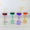Four glass hourglass timers filled with colorful liquids demonstrating different colors and patterns.