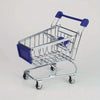A silver mini shopping cart desktop organizer with blue handles and rolling wheels.