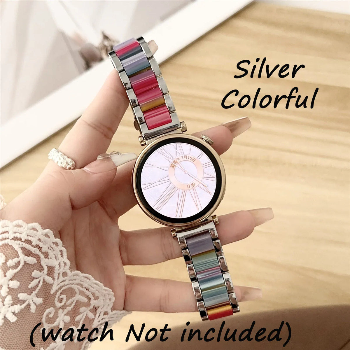 Eine Hand hält eine silberne bunte Uhr mit mehreren Harz-Metallbändern und einer minimalistischen Zifferblatt.