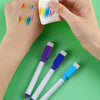 A hand holds a white cloth with colorful paint marks, next to an 8-pack of magnetic whiteboard pens.