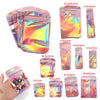 A collection of iridescent self-sealing jewelry pouches in various sizes and colors shown next to a hand.