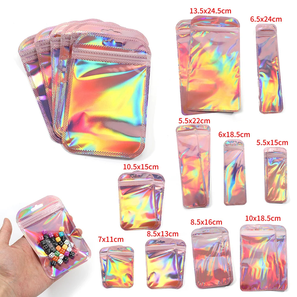A collection of iridescent self-sealing jewelry pouches in various sizes and colors shown next to a hand.