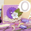 A craft adhesive tape set featuring purple and white floral elements on a card background.
