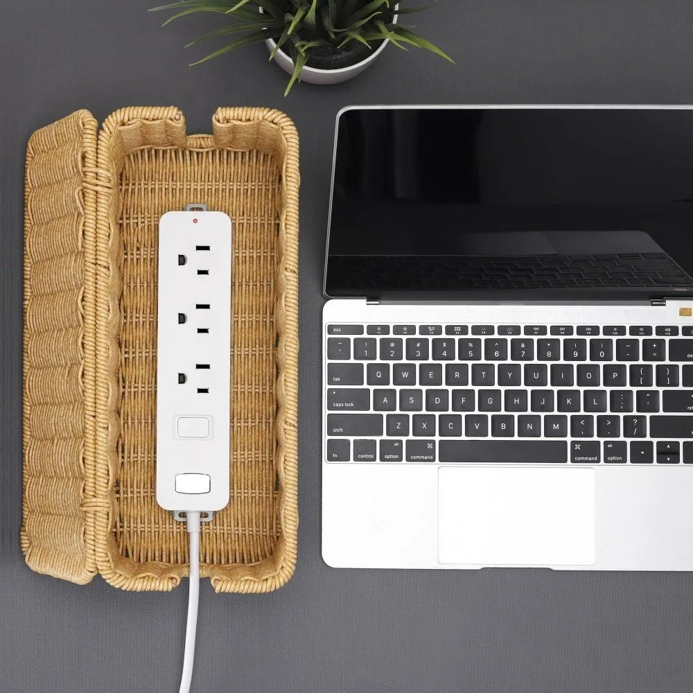 A handwoven rattan cable management box with a lid next to a silver USB cable and a laptop.